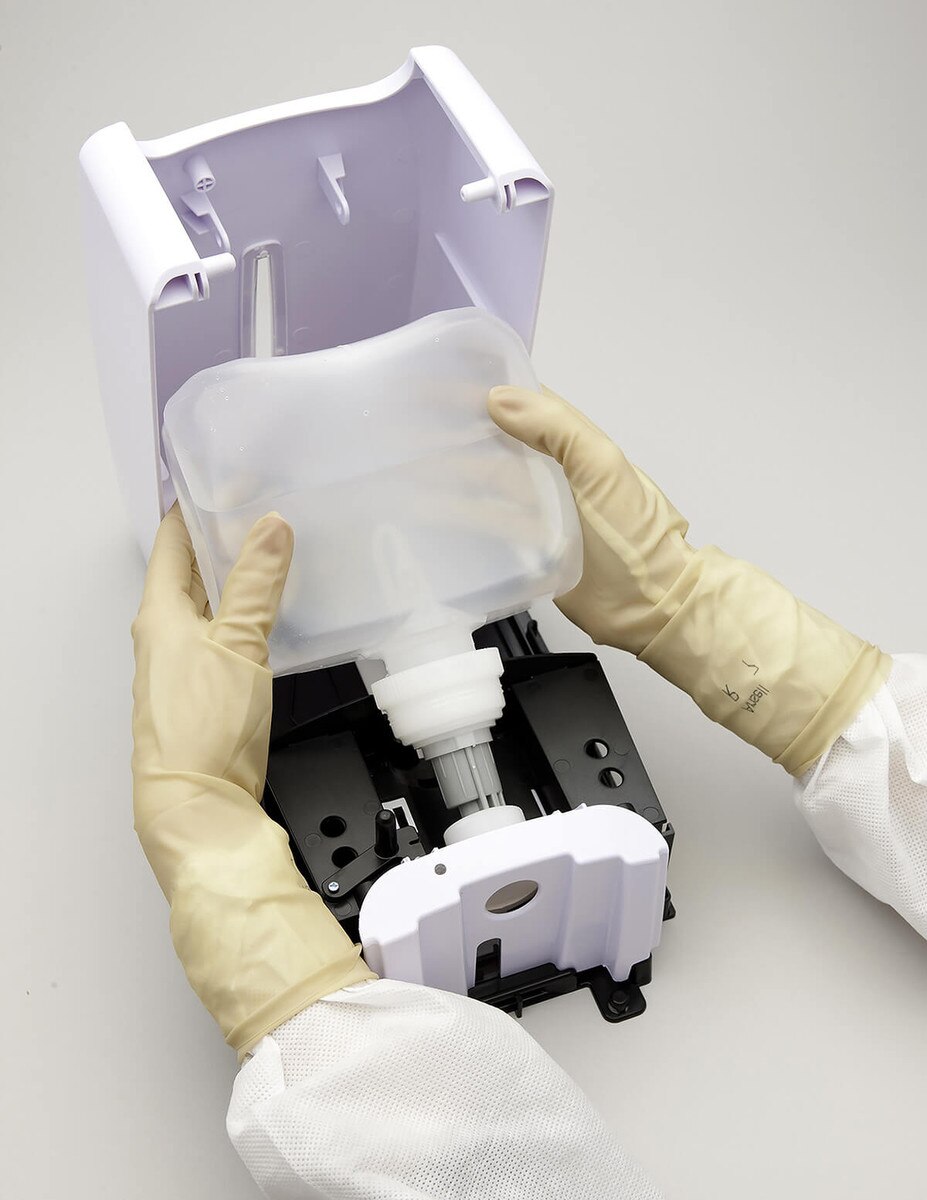 Hands installing the DECON-HAND 32 oz ASEPTI-CLEANSE refill pouch into a wall-mounted dispenser unit.