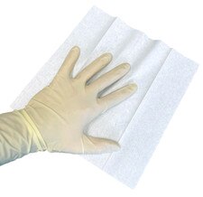 Gloved hand placed on a single unfolded 9x9 cleanroom wipe showing soft dry poly-cellulose texture